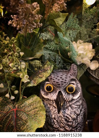 Halloween scene : Cute owl figure sculpture made from paper mache decorated with multi flower and tree branch 