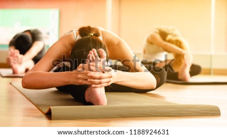 Class of yoga with multi nation people student streching back and legs Royalty-Free Stock Photo #1188924631