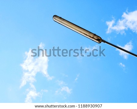 Close-up shot of an old street lamp in front of building with blue sky as a background