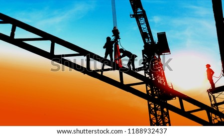 silhouette of construction worker working on hoist crane  Royalty-Free Stock Photo #1188932437