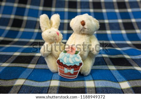 figurine of a teddy bear, a white teddy bear, a plush rabbit, toys, small figures, a blue background, a cake, a cake figurine, a checkered blue background, a series