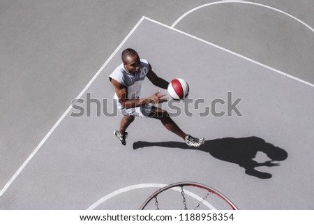 Picture of young confused african basketball player practicing outdoor. Fit afro man in motion and movement. athletic and sport lifestyle concept. Top view