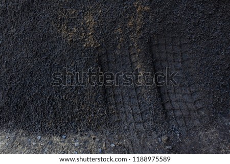 tire tracks on gray textured ground