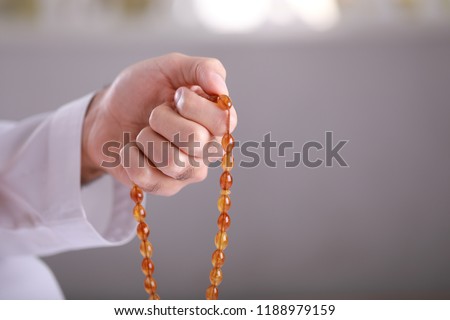 Praying hands of an young Arab Muslim man holding rosary beads, masbaha, subha, islamic concept, Royalty-Free Stock Photo #1188979159