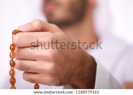 Praying hands of an young Arab Muslim man holding rosary beads, masbaha, subha, islamic concept, Royalty-Free Stock Photo #1188979165