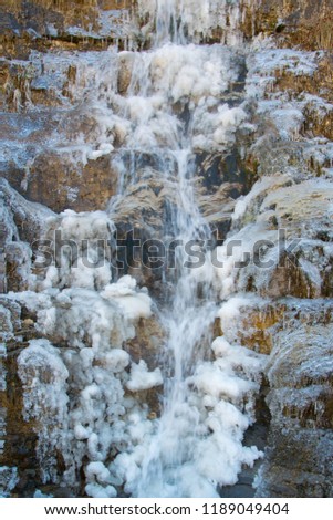 Nature power - close up of frozen natural mountain waterfall