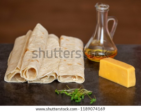 cheese, sunflower oil and thin pita bread lies on a gray stone b