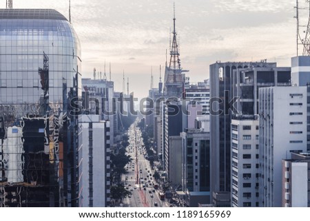 Aerial view of Paulista avenue on the afternoon in a cloudy day. Cars, avenues, commucation tower and business buildings compose the picture. Famous place, architecture and urban as a concept