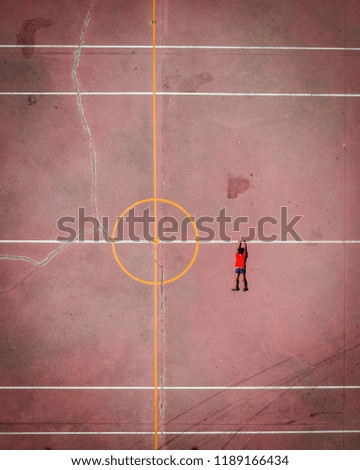 Aerial view of boy clinging to a line drawn on the tennis court