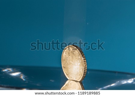 High speed macro picture of water drops and euro coins falling with a blue background