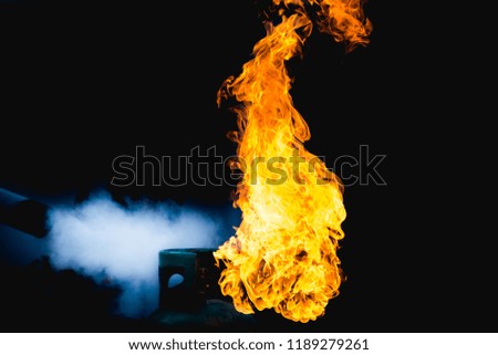Texture of fire background. Fire flames using as a background or wallpaper. People using fire extinguisher fighting fire closeup photo.