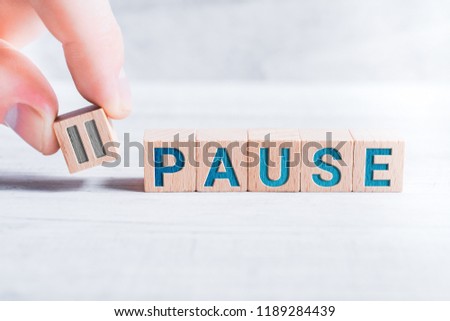 The Word Pause Formed By Wooden Blocks And Arranged By Male Fingers On A White Table Royalty-Free Stock Photo #1189284439