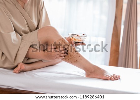 close up beautiful asian women applying beauty scrub and mask to her leg at home