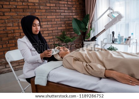 Picture of beautician doing rf procedure for women laying in a beauty salon