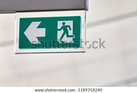 Emergency exit signage with arrow in airport terminal