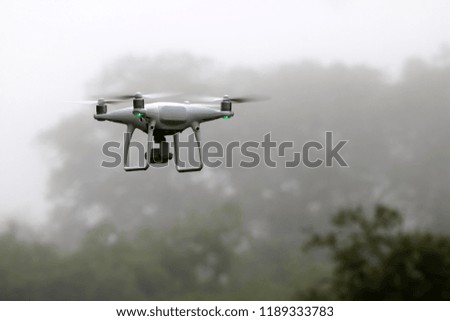 Drone Camera flying in the sky while the rain with mist, forests background