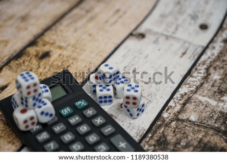 Conceptual image calculator with dice on wooden background. Concept for business risk, chance, good luck or gambling. Copy space for text. Selective focus.