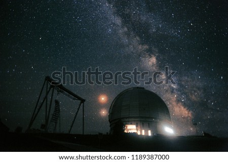 Starry sky during an eclipse over a telescope in the mountains