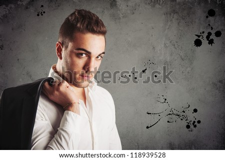 Young man close up portrait against dark grunge background.