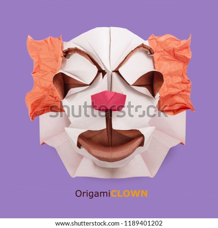 Origami paper clown face isolated on violet