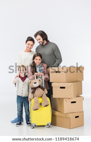 Little boy holding key from new house ready to move with his family into new house isolated on white 