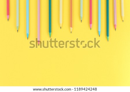 multicolored pencils on a yellow isolated background, office supplies, top view. a lot of free space. flat lay concept.