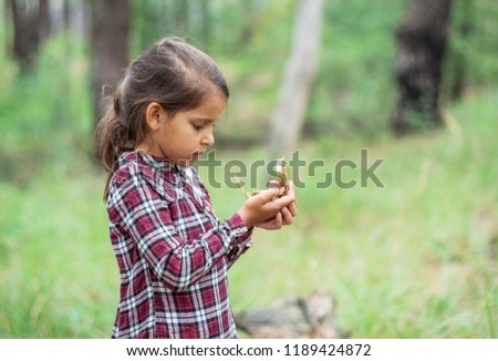 Small girl is looking at her compass. Young traveller.