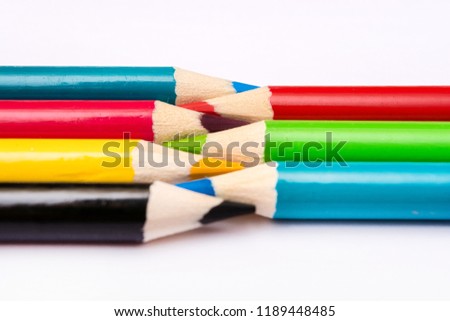 Seven colored pencils. The colors red, green, blue, cyan, magenta, yellow and black. Concept of color profiles converting from RGB to CMYK.