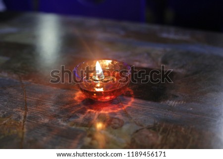 Isolated shot of Candle on a table in a bowl with red oil in it. 