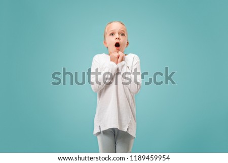 I'm afraid. Fright. Portrait of the scared teen girl. She standing isolated on trendy blue studio background. Female half-length portrait. Human emotions, facial expression concept. Front view