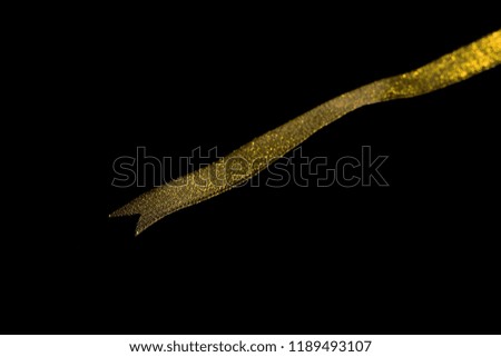 Golden ribbon isolated on black background and texture, with clipping path