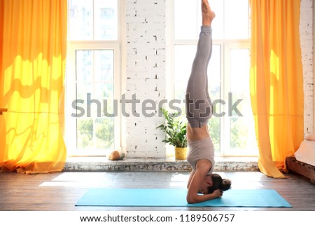 Sporty woman practicing yoga at home