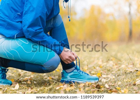 Sport runner woman tying laces before training. Marathon