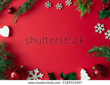 Red Christmas background with winter decoration, tree branches and leaves. Holiday copy space layout.