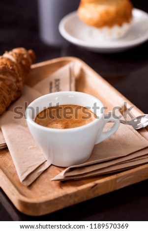 Croissant and coffee on a wooden tray. Breakfast table. Food and drink conception.