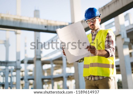 Picture of construction site engineer looking at plan
