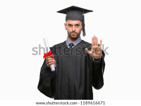 Young handsome graduated man holding degree over isolated background with open hand doing stop sign with serious and confident expression, defense gesture
