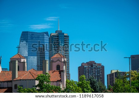 Denver Colorado Modern office building skyscrapers rise up from downtown behind old historic church 