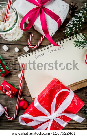 Christmas concept, preparation for xmas holidays, notepad for wish list, santa letter. to do list, with hot hot chocolate cup, Christmas tree decor, fir branches. Old wooden table copy space top view