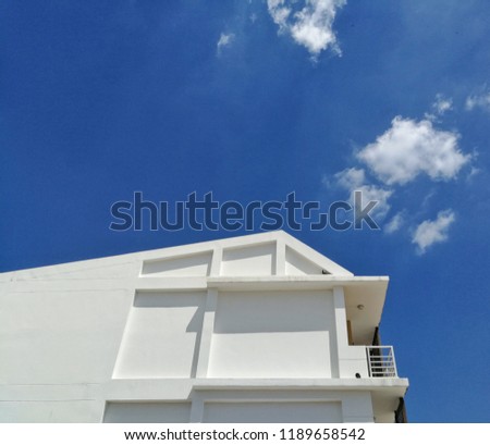 white building on blue sky background.​