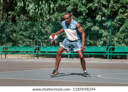Picture of young confused african basketball player practicing outdoor. Fit afro man in motion and movement. athletic and sport lifestyle concept