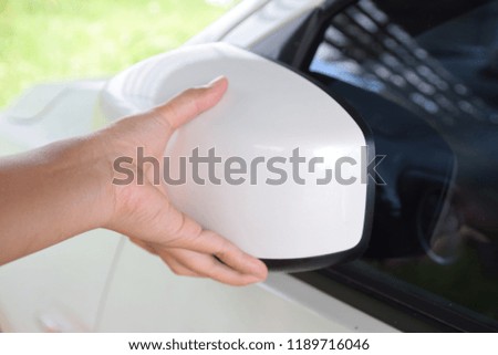 hand touch a white  car auto mirror and try to twist