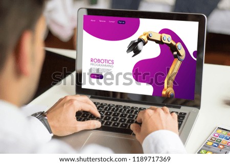 businessman browsing robotics website with a laptop All screen graphics are made up.