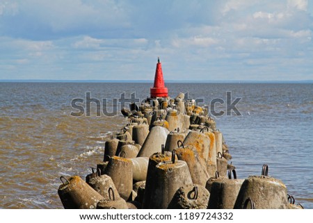 Red navigational signal buoy on the breakwaters