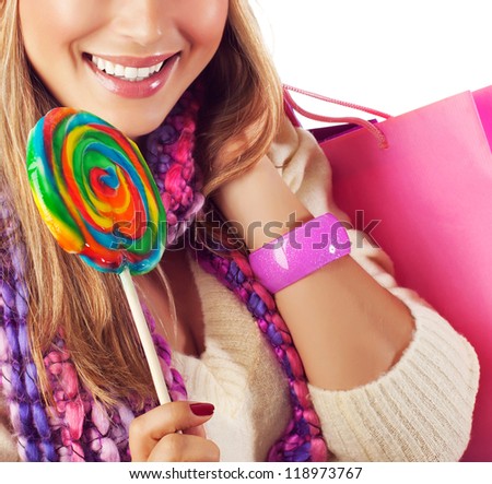 Picture of pretty woman eating sweet candy, cute girl with perfect smile holding pink shopping bag and licking big colorful lollipop, Christmas present, New Year holiday, sweets shop sale concept