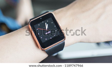 Close up wrist watches with icons and gray aluminum case, Black sport band. Black fitness watch (activity tracker) on Laptop background. A Man using his smart watch app and connect mobile. Businessman