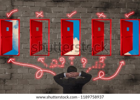 
Rear view of businessmen confused with many red doors at brick wall. Concepts of decision making and right choice of business, and risk management in organization,  Including leadership.