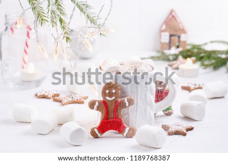 Cup of traditional hot chocolate with marshmallows and gingerbread on white table.  Christmas drink in New Year decorations. Copy space.