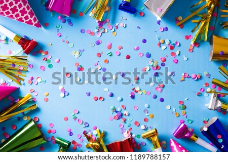 Party background. Party caps and confetti on blue  background. Top view. Copyspace