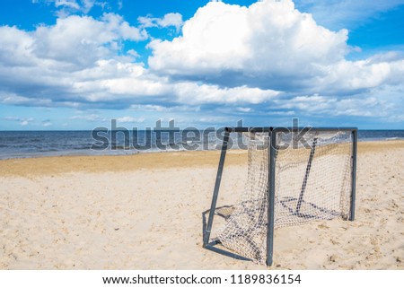 The football gate left on the empty beach in a bright sunny day of the beginning of autumn. Bright sunny day on the beach.